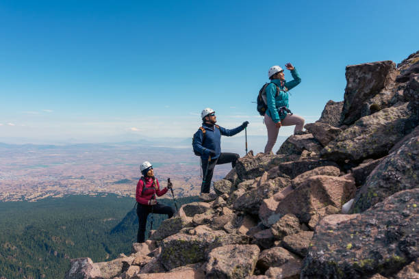 three people climbing a mountain